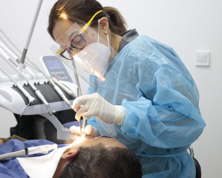 Dentista atendiendo a un paciente en una consulta dental.