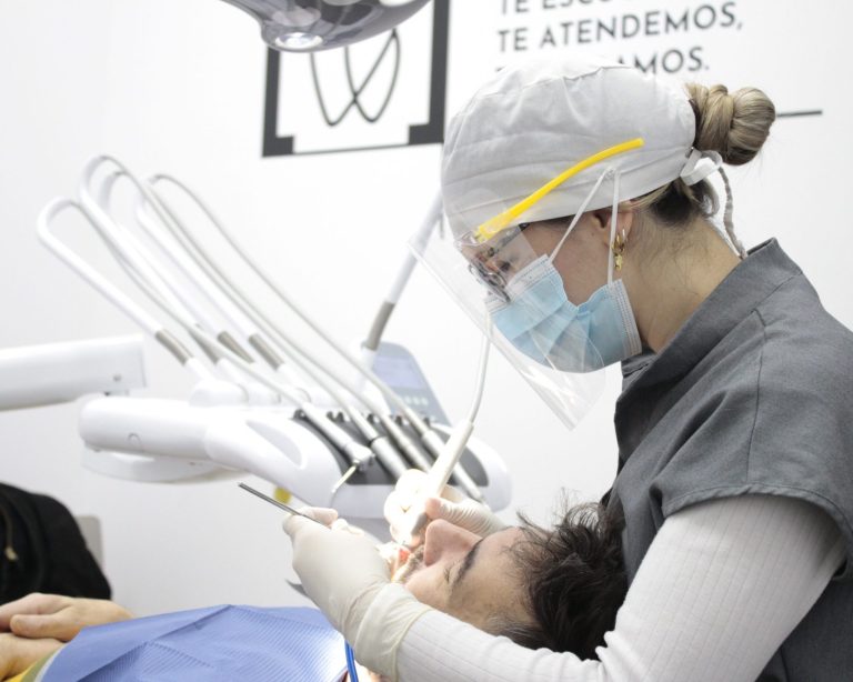 Dentista atendiendo a un paciente en una consulta dental.