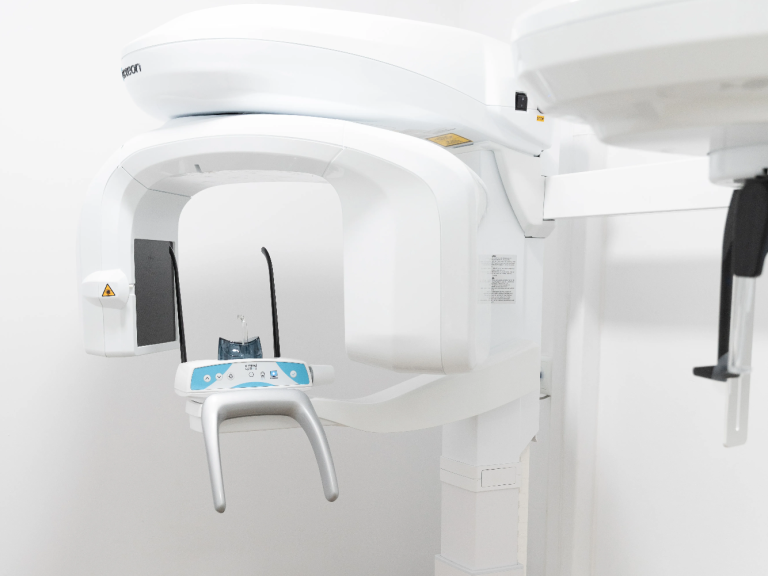 Máquina de radiografía dental con brazo móvil en un entorno clínico.